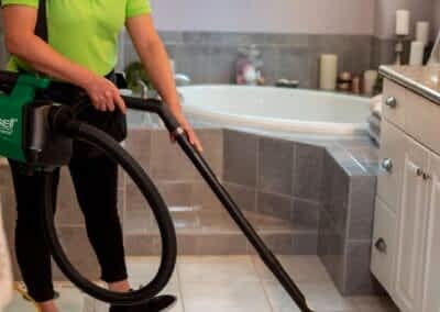 Vacuuming kitchen floor | Helping Hands Cleaning Services